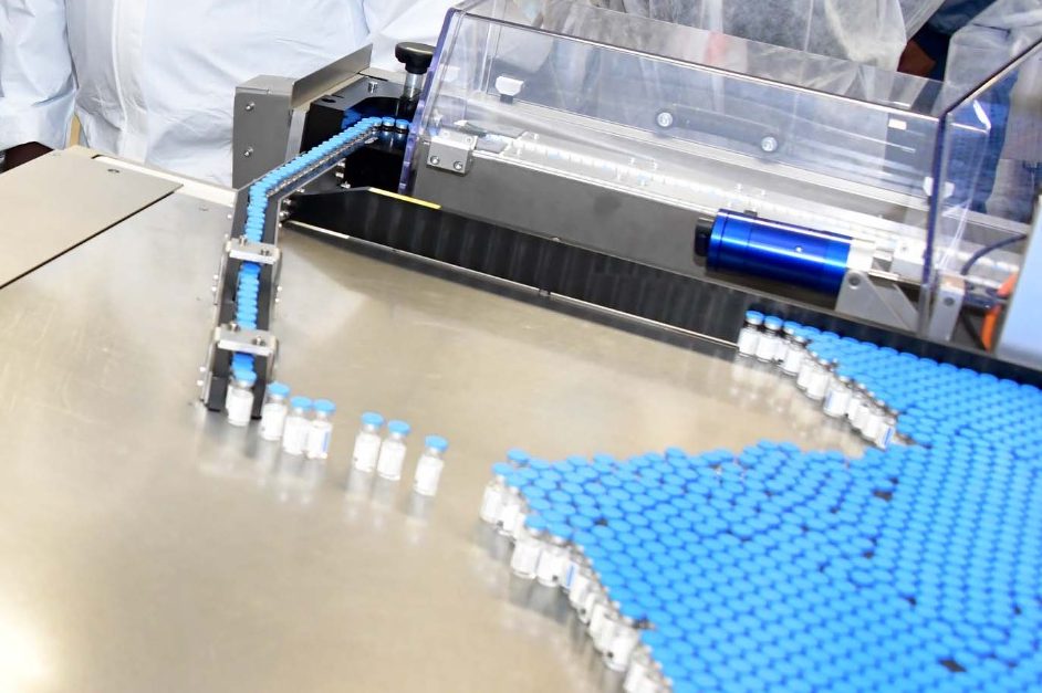 Blue capped vials streaming out of a production line.